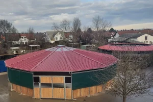 Longierhallen mit Douglasiebrettern gefüllt, mit rotem Dach bedeckt