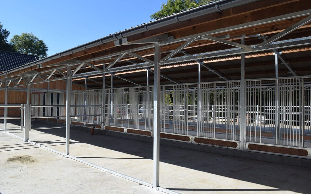 Weidehütte für Pferde mit Paddocks auf beiden Seiten des Gebäudes